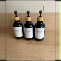 Los tres dispensadores negros de frente, con tapa de bambu